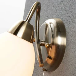 Aplique de pared Lindby Mael, altura 20 cm, latón envejecido, interruptor