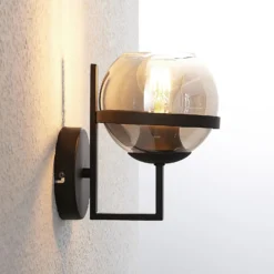 Aplique de pared Lindby Marinka, altura 20 cm, negro, cristal ahumado