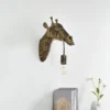 Aplique de pared Lindby Nirvathia, 35 cm, jirafa, color latón