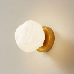Aplique de pared Lindby Piatra, opal/latón, cristal, Ø 16 cm, G9