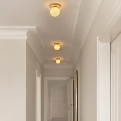 Aplique de pared Nuura Liila 1 Medium, dorado/amarillo miel, IP44, G9