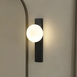 Aplique para baño Lindby Tavrik, negro/blanco, altura 30 cm, cristal